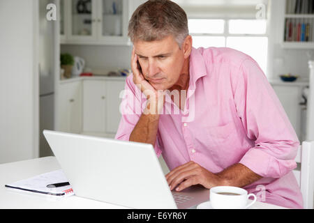 Mid age man working on laptop at home Stock Photo