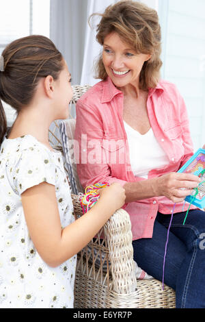 Senior woman doing cross stitch with granddaughter Stock Photo