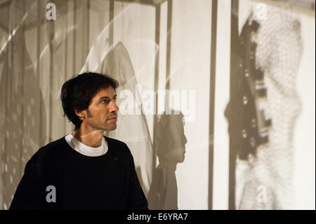 London, UK. 2nd Sept, 2014. Artist Xavier Mascaró looks at the shadow of one of his works 'Masks'. Xavier Mascaró's first UK solo exhibition will run from 3 September until 5 October at Saatchi Gallery. Credit:  Piero Cruciatti/Alamy Live News Stock Photo