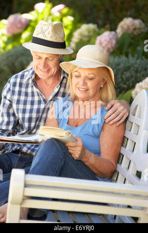 Senior couple reading in garden Stock Photo