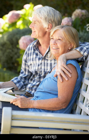 Senior couple reading in garden Stock Photo