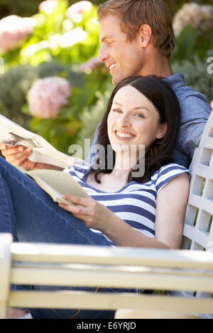 Couple reading in garden Stock Photo