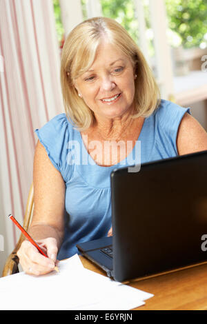 Senior Woman Working In Home Office Stock Photo