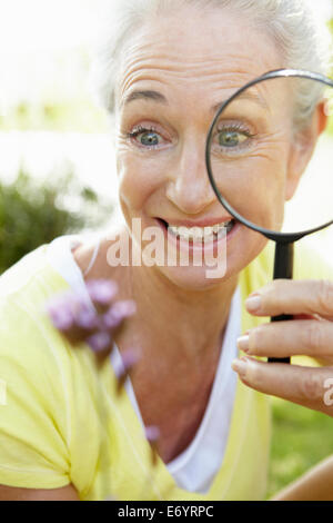 Senior woman with magnifying glass Stock Photo