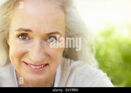 Senior woman sitting on grass Stock Photo