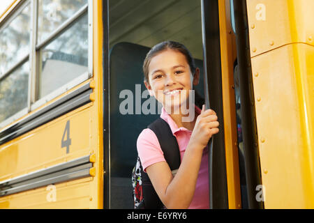 Pre teen girl getting on school bus