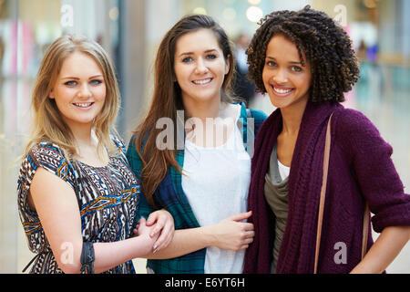 Three Female Friends Shopping In Mall Together Stock Photo