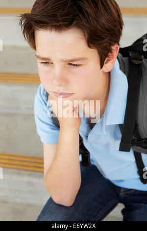 Unhappy Pre teen boy at school Stock Photo