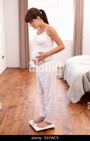 Pregnant woman weighing herself Stock Photo