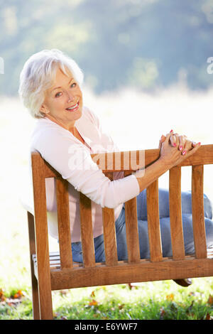 Senior woman sitting outdoors Stock Photo