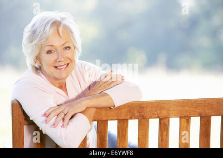 Senior woman sitting outdoors Stock Photo