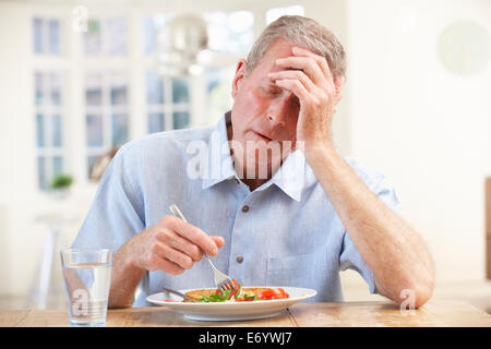 Sick older man trying to eat Stock Photo