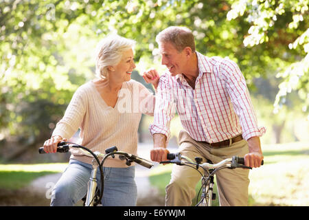 Senior couple cycling in park Stock Photo