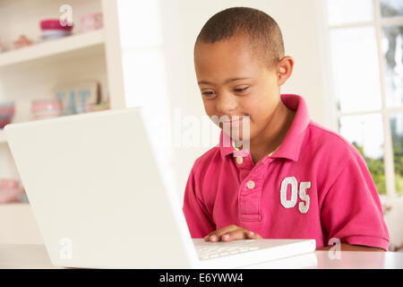 Downs Syndrome boy with laptop Stock Photo