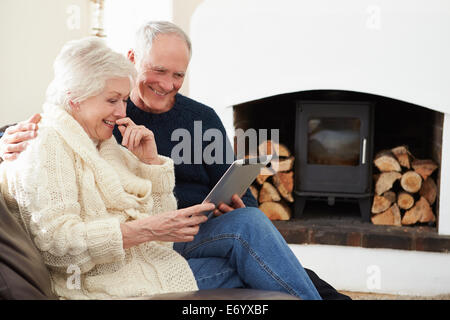 Senior Couple Using Digital Tablet On Sofa Stock Photo