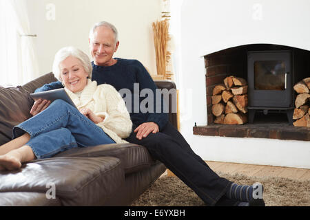 Senior Couple Using Digital Tablet On Sofa Stock Photo