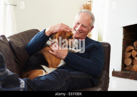 Senior Man Relaxing At Home With Pet Dog Stock Photo