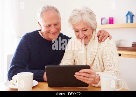 Senior Couple Using Digital Tablet At Table Stock Photo