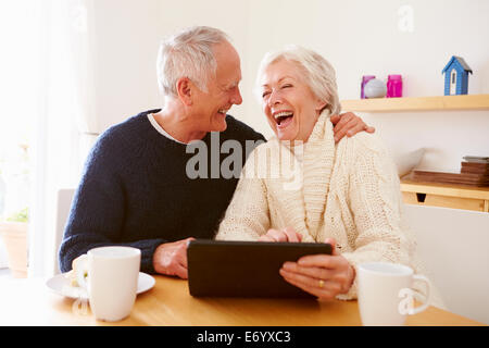 Senior Couple Using Digital Tablet At Table Stock Photo