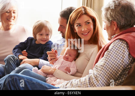 Young Couple Sitting On Roof Terrace Using Laptop Stock Photo