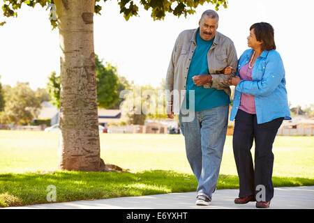 Senior Couple Walking In Park Together Stock Photo