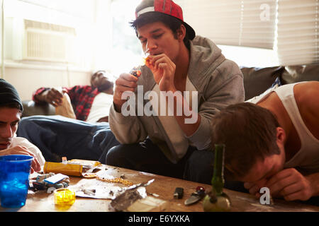 Gang Of Young Men Taking Drugs Indoors Stock Photo