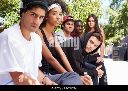 Gang Of Young People In Urban Setting Sitting On Bench Stock Photo