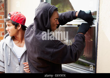 Two Young Men Breaking Into House Stock Photo