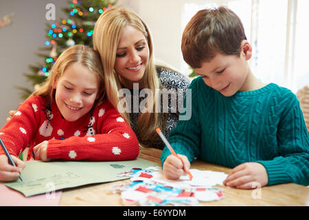 Mother And Children Writing Letter To Santa Together Stock Photo