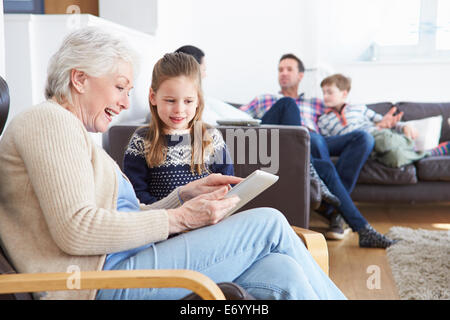 Grandmother And Granddaughter Using Digital Tablet Together Stock Photo