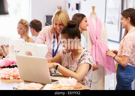 Teacher Helping College Students Studying Fashion And Design Stock Photo