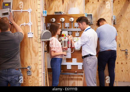 Teacher Helping Students Training To Be Electricians Stock Photo