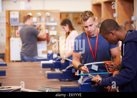 Teacher Helping Students Training To Be Electricians Stock Photo