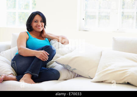 Portrait Of Overweight Woman Sitting On Sofa Stock Photo