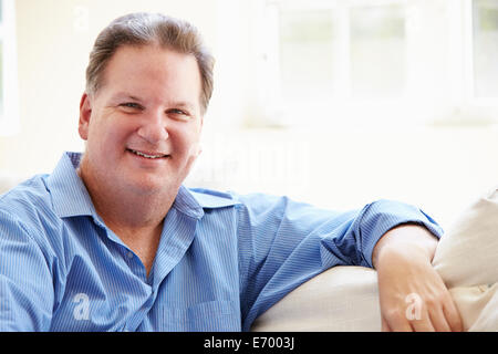 Portrait Of Overweight Man Sitting On Sofa Stock Photo