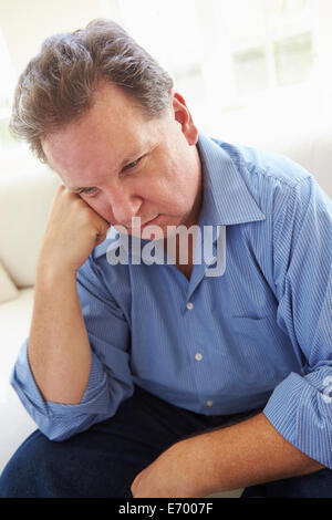 Depressed Overweight Man Sitting On Sofa Stock Photo