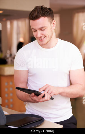Waiter In Hotel Using Digital Tablet Stock Photo