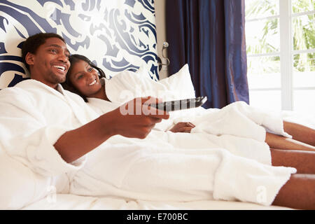 Couple Relaxing In Hotel Room Watching Television Stock Photo