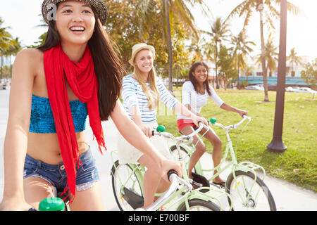Female Friends Having Fun On Bicycle Ride Stock Photo