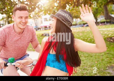 Young Couple Having Fun On Bicycle Ride Stock Photo