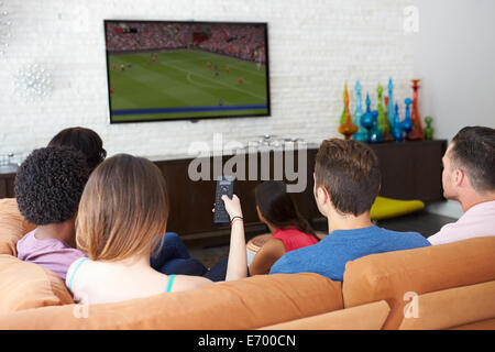 Group Of Friends Sitting On Sofa Watching Soccer Together Stock Photo