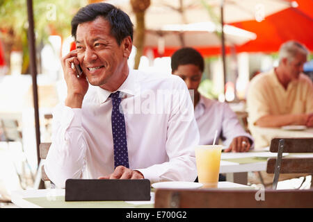 Businessman Working On Digital Tablet In Outdoor Café Stock Photo