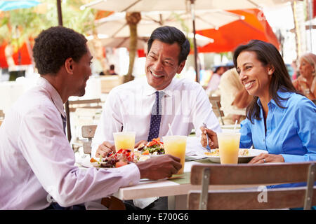 Three Businesspeople Having Meeting In Outdoor Restaurant Stock Photo