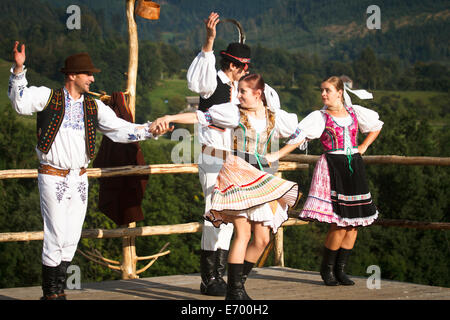 Czech folklore dancers, wearing traditional costume, performing traditional dance on stage in Beskidy mountains. Stock Photo