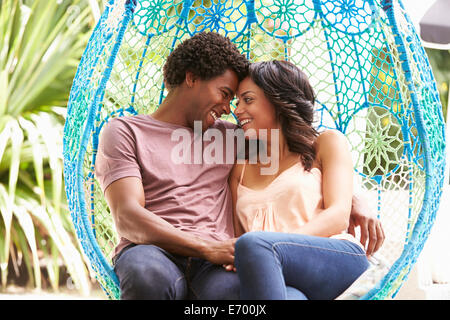 Couple Relaxing On Outdoor Garden Swing Seat Stock Photo