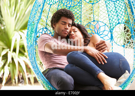 Couple Relaxing On Outdoor Garden Swing Seat Stock Photo