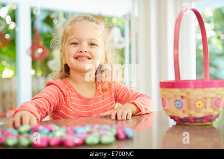 Girl With Chocolate Easter Eggs And Basket At Home Stock Photo