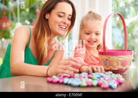 Mother And Daughter With Chocolate Easter Eggs And Basket Stock Photo
