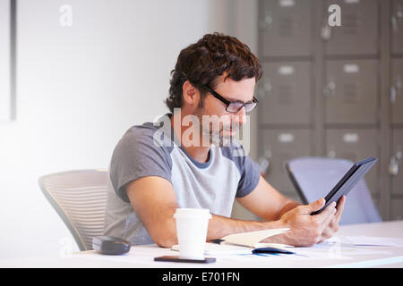 Casually Dressed Man Using Digital Tablet In Design Studio Stock Photo