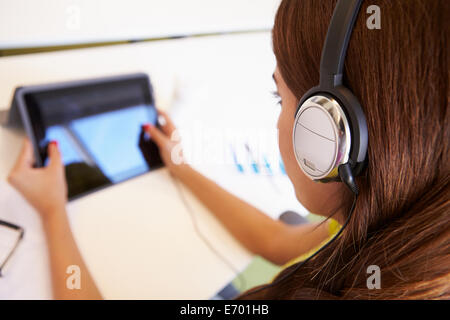 Woman Using Digital Tablet And Headphones In Design Studio Stock Photo
